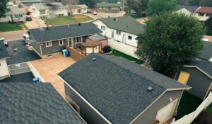 Aerial view of suburban neighborhood with houses and tree-lined streets.