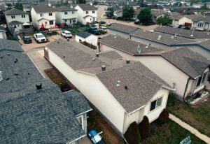 Aerial view of a suburban neighborhood with houses and parked cars.